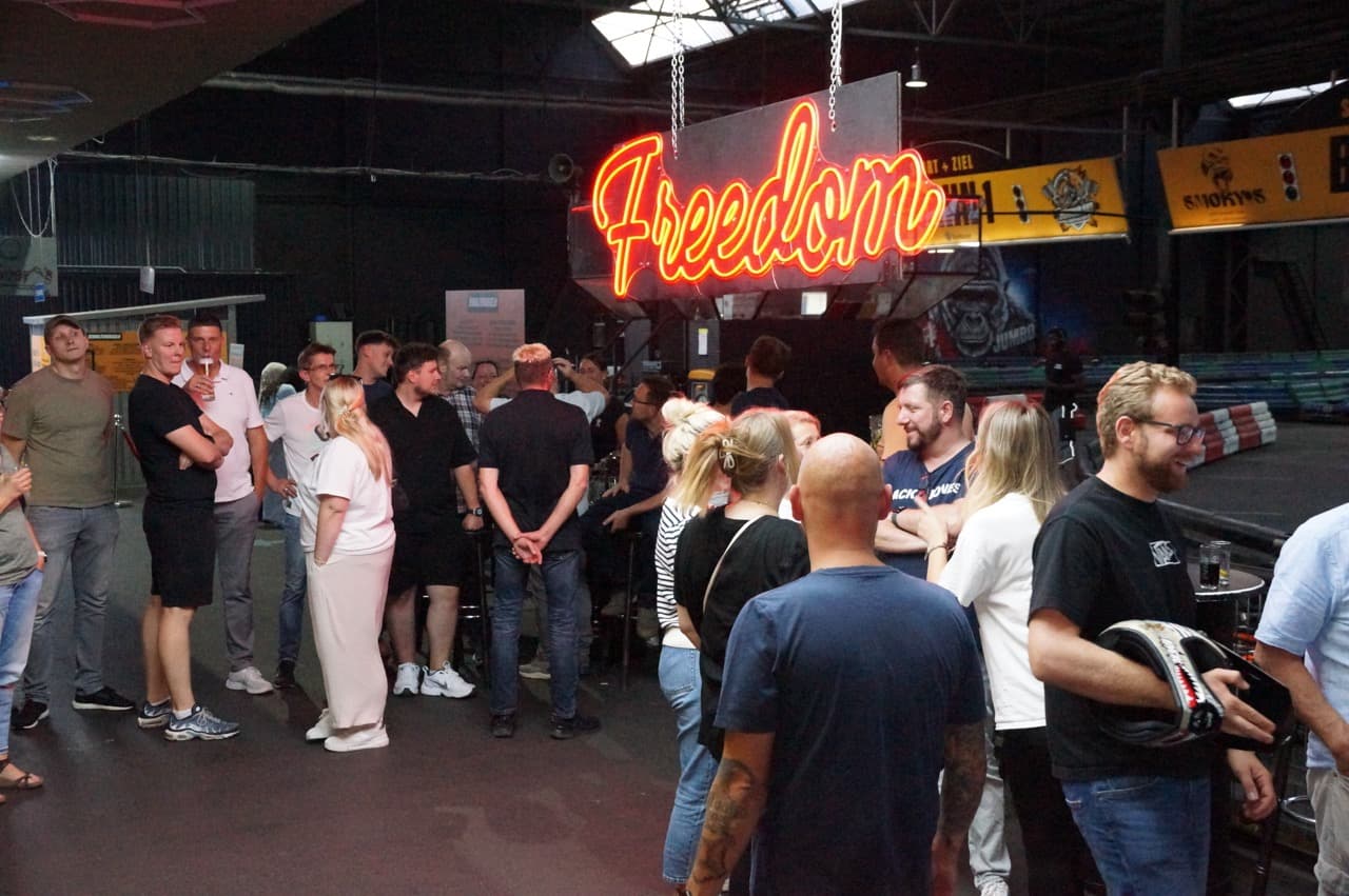Gruppe versammelt sich gemeinsam neben der Kartbahn